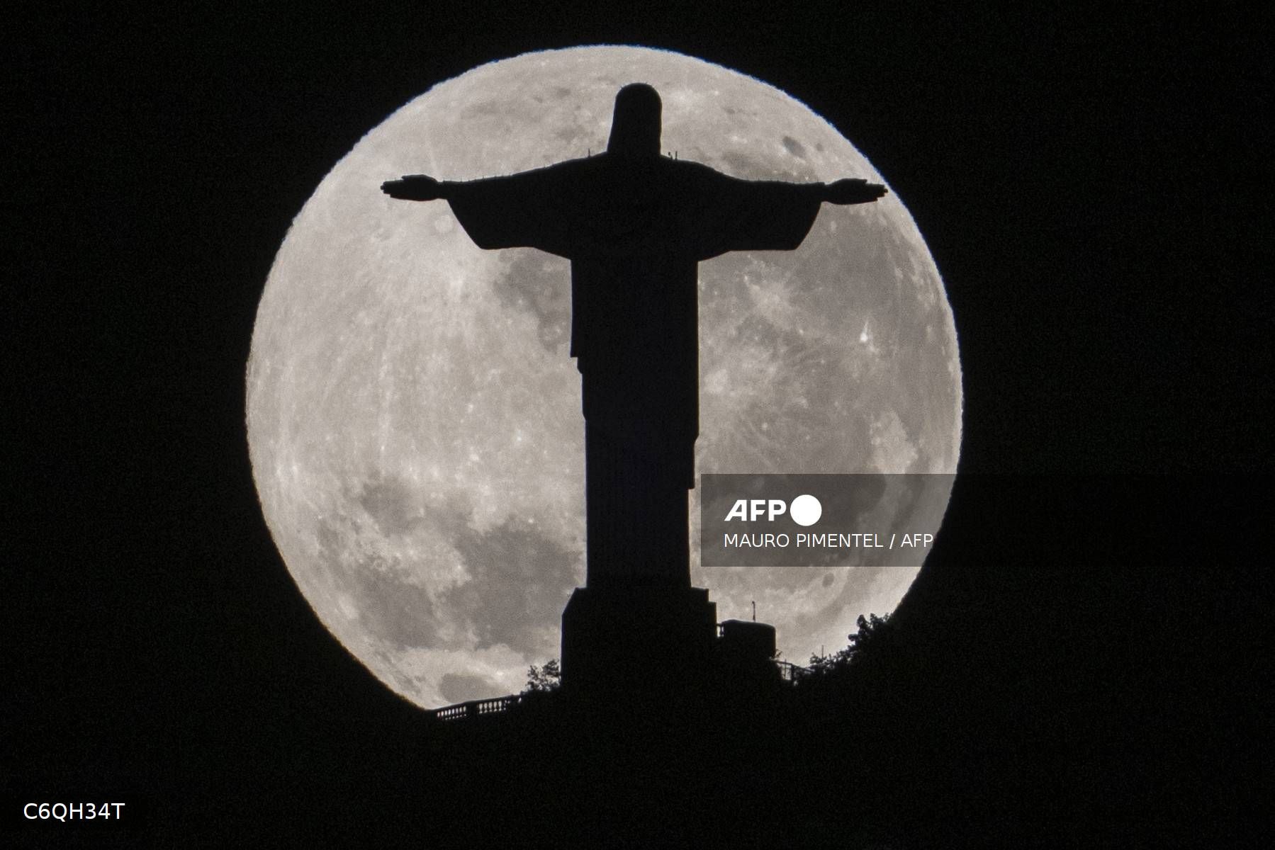Se observa la silueta de la estatua del Cristo Redentor recortada contra la luna llena —también conocida como la «Luna del Esturión»— en Río de Janeiro, Brasil.