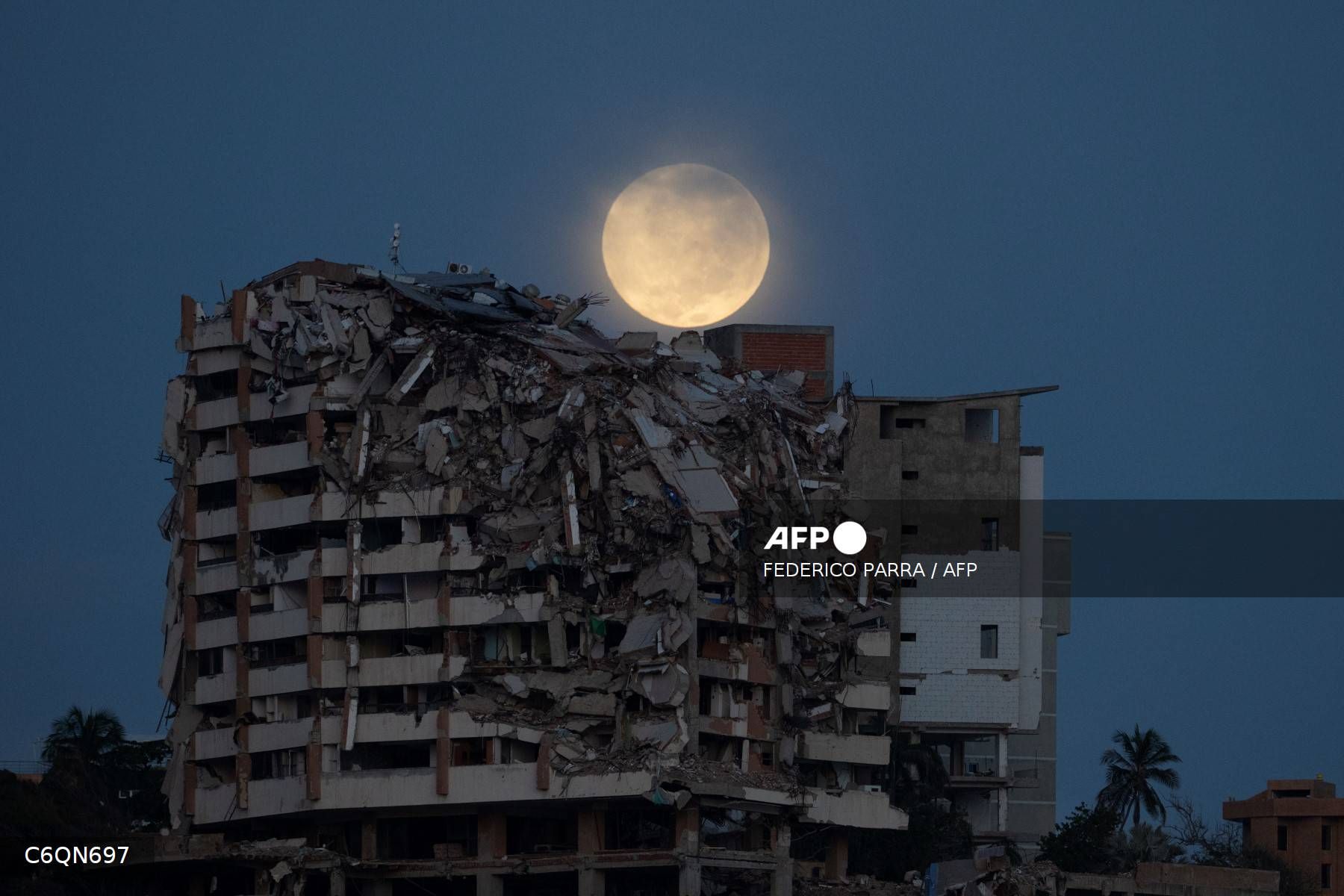 Se observa la luna llena detrás de un edificio residencial colapsado en Catia La Mar, estado de La Guaira, Venezuela, el 28 de agosto de 2026, más de dos meses después de que terremotos de magnitudes 7,2 y 7,5 sacudieran la zona.