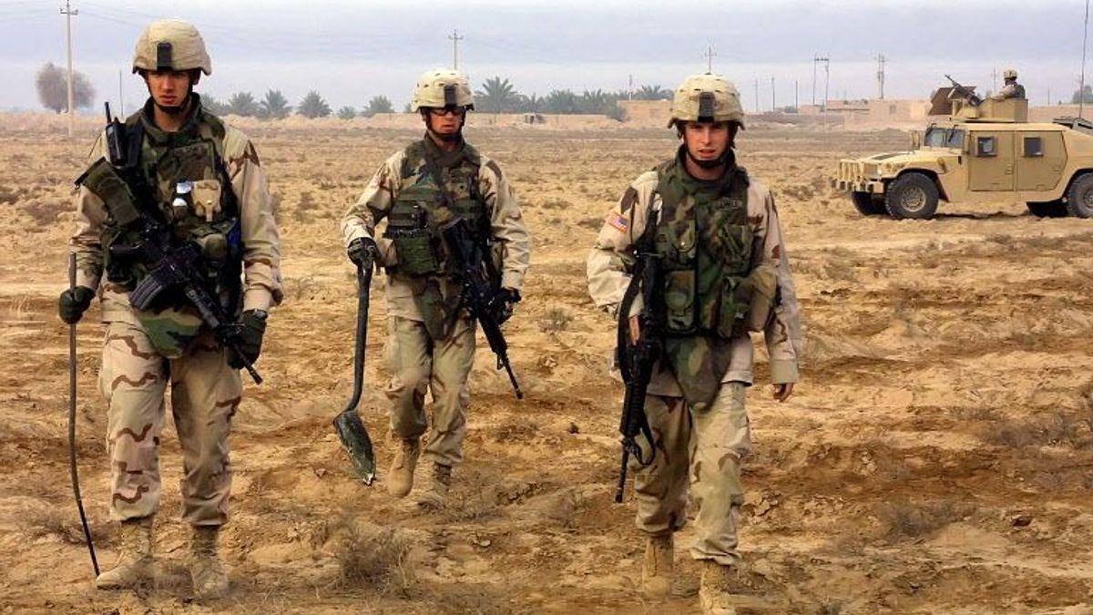 Un soldado estadounidense (C), armado con una pala, llega con sus compañeros para desenterrar armas en la aldea de Shateb, a 40 km al noreste de Bagdad, el 13 de diciembre de 2005.