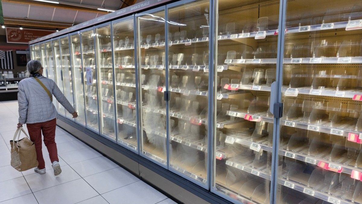 Una mujer pasa junto a refrigeradores vacíos de alimentos frescos en un supermercado Intermarché en Névez, al oeste de Francia